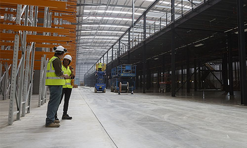 MiTek employees in warehouse with mezzanine floor and racking