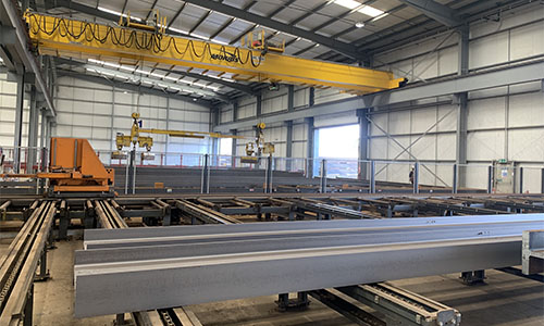 Inside the warehouse of a steel fabricator with hot rolled steel elements
